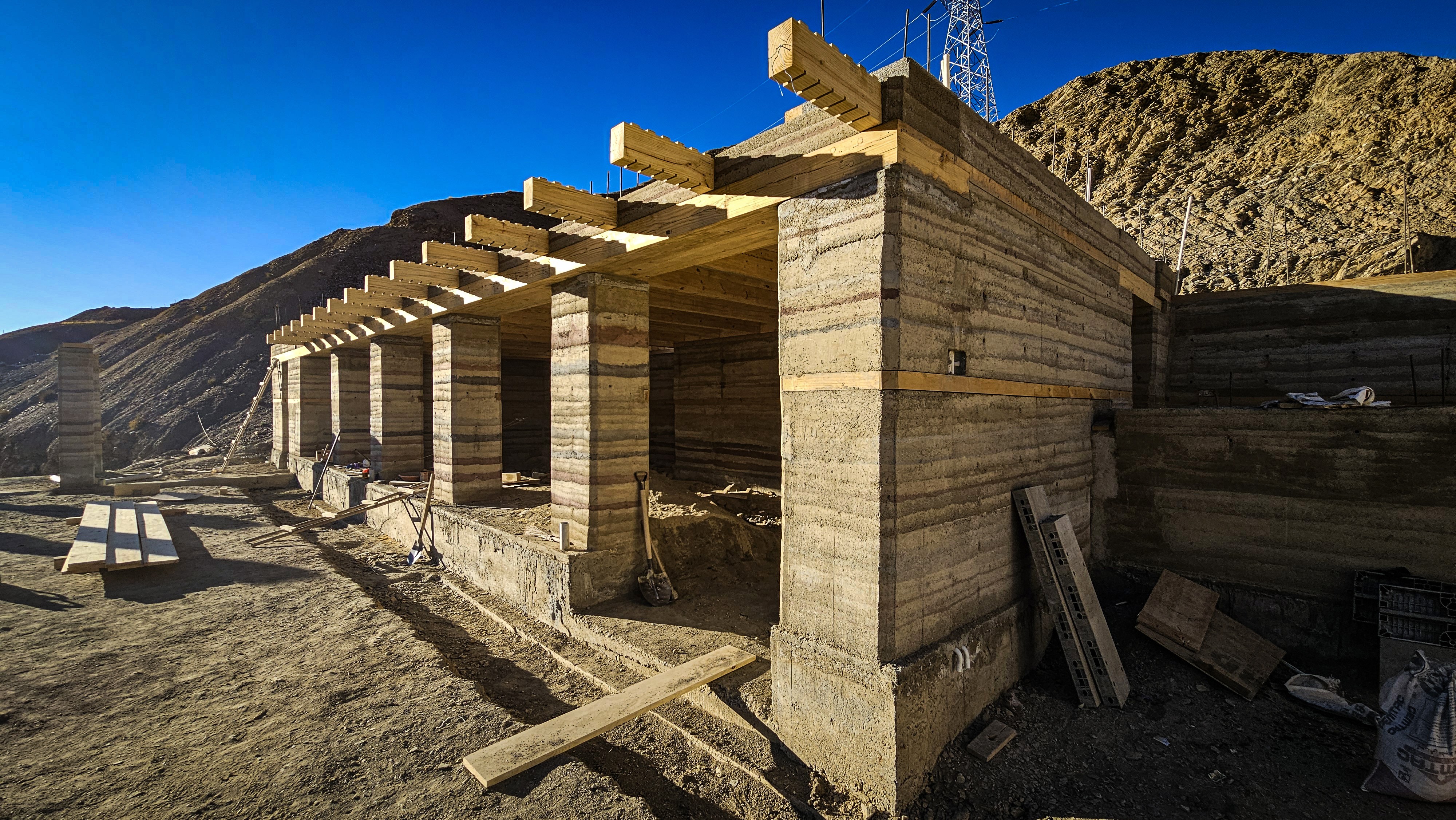 Building from the land: The structure rises naturally from its arid context, utilizing local soil to create high-thermal-mass walls that will eventually protect against the harsh elements.