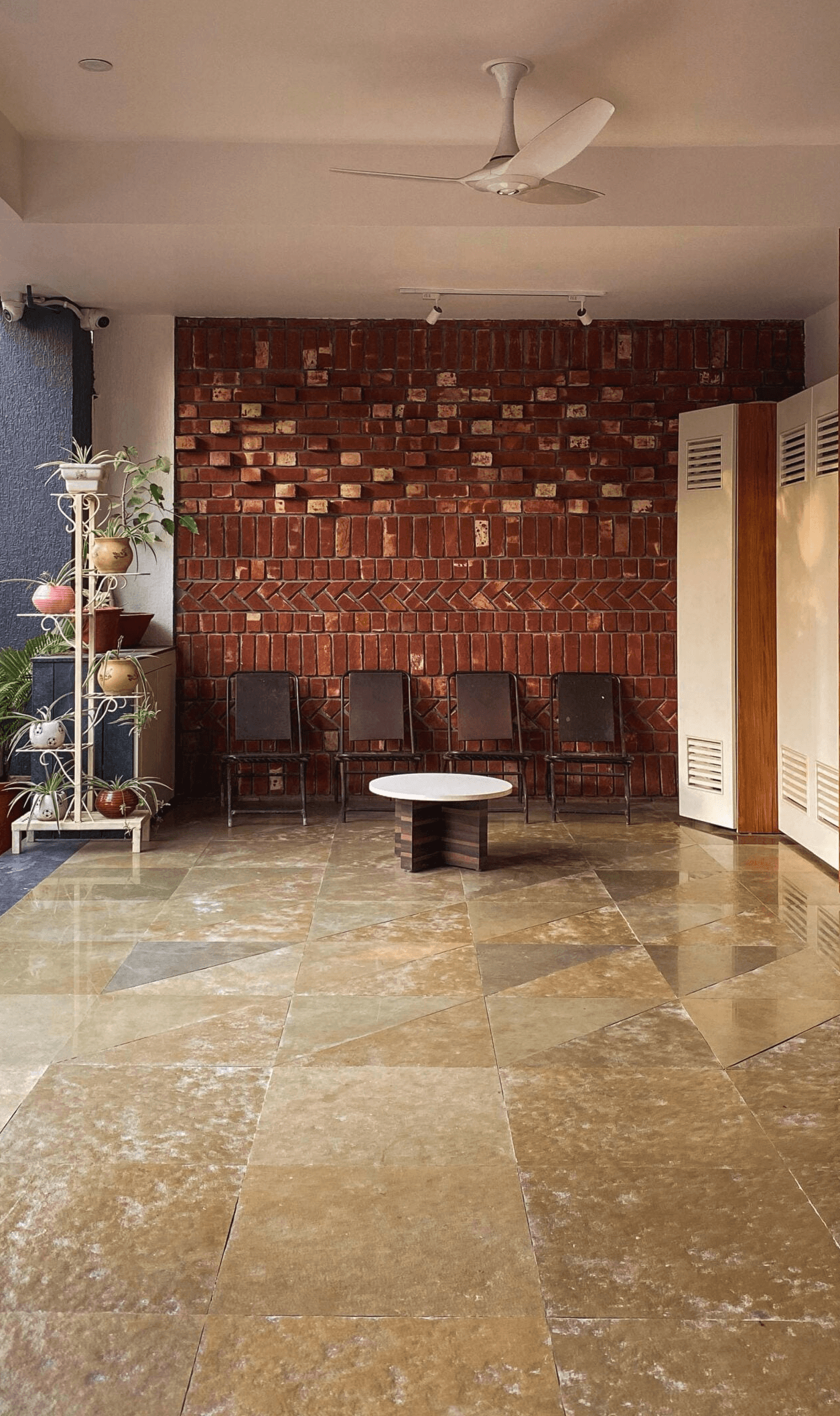 An Entrance space articulated through exposed brick Facade, natural stone flooring setting a clear and welcoming threshold to the home.