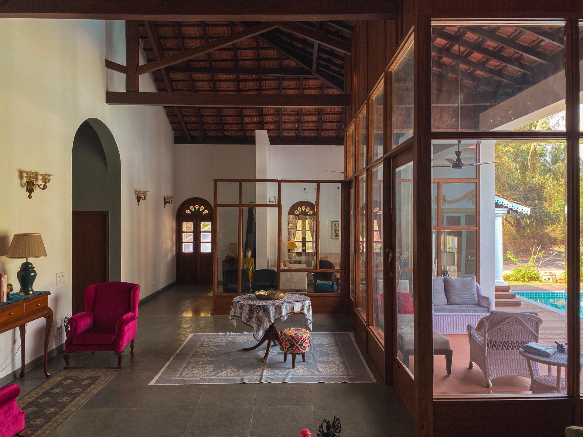 A room with a view: Wood-framed glass walls frame the serene pool and lush garden, flooding the living space with natural light.