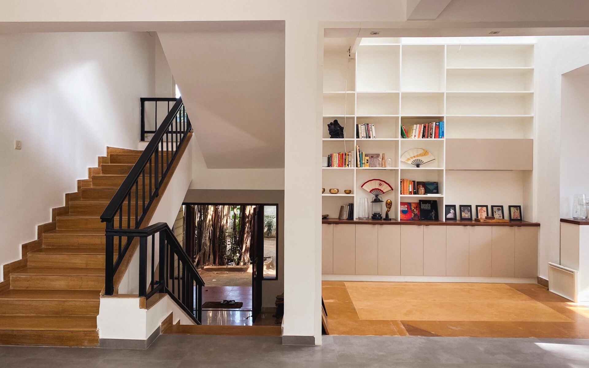 A bibliophile's dream: The double-height living space is anchored by a floor-to-ceiling white bookshelf, creating a sophisticated yet functional focal point.